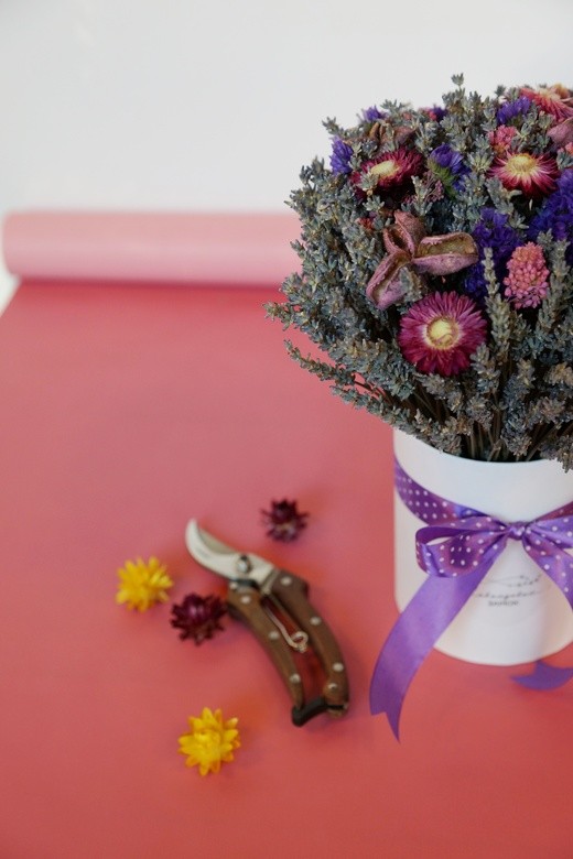 Фото яркой композиции из сухоцветов в шляпной коробке. 