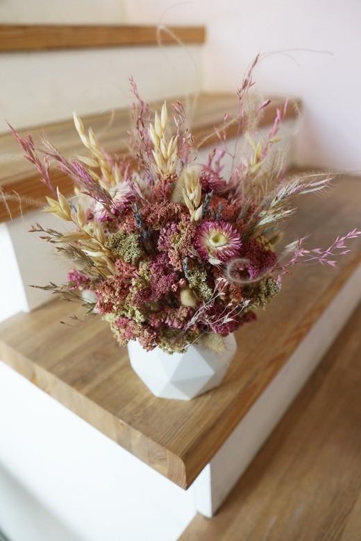 Фото яркой композиции из сухоцветов в бетонном кашпо в интерьер. 