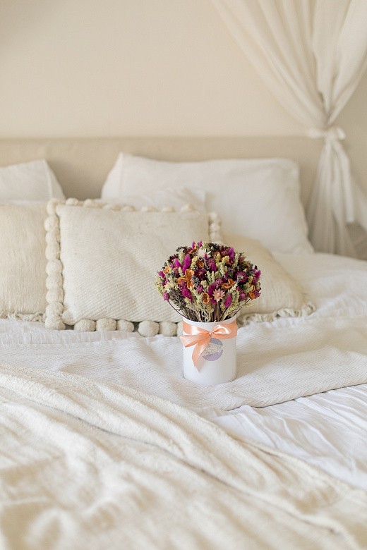 Фото яркой композиции из сухоцветов в шляпной коробке. 